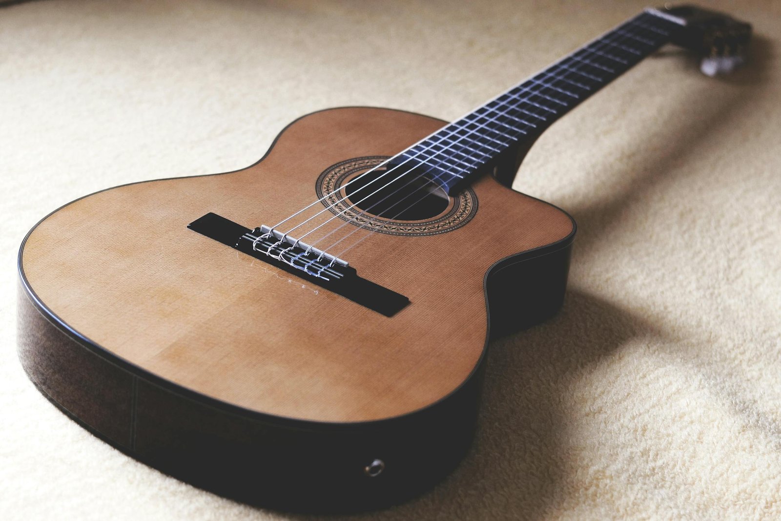 Detailed shot of a classical acoustic guitar highlighting strings and craftsmanship.