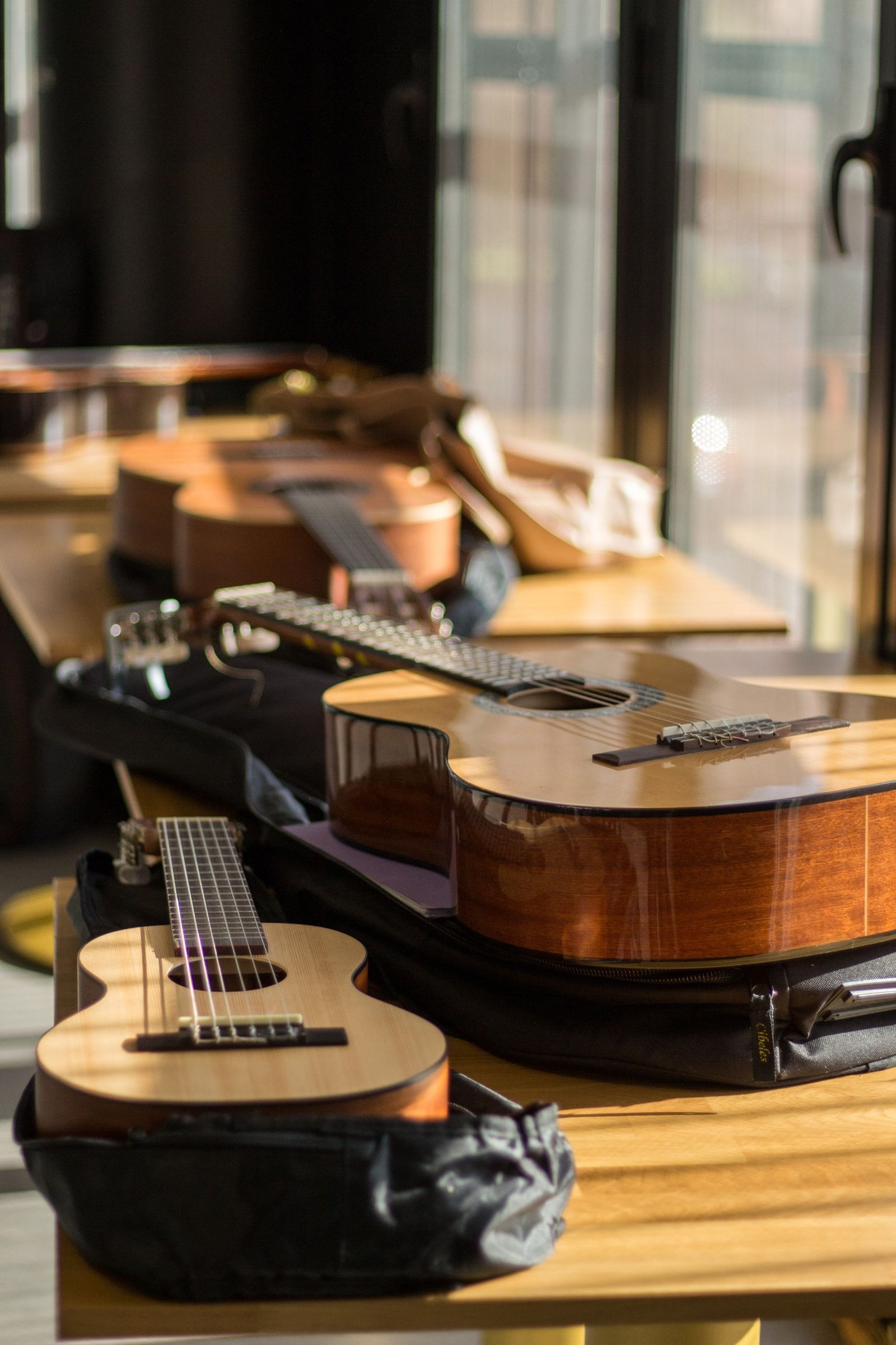 A collection of acoustic guitars displayed on a wooden table in a well-lit room.